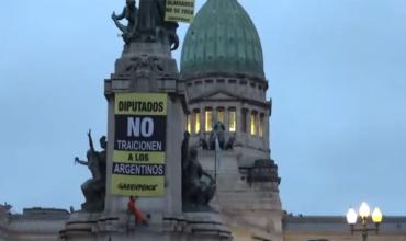 Activistas de Greenpeace treparon a un monumento frente al Congreso con banderas contra la modificación de la Ley de Glaciares